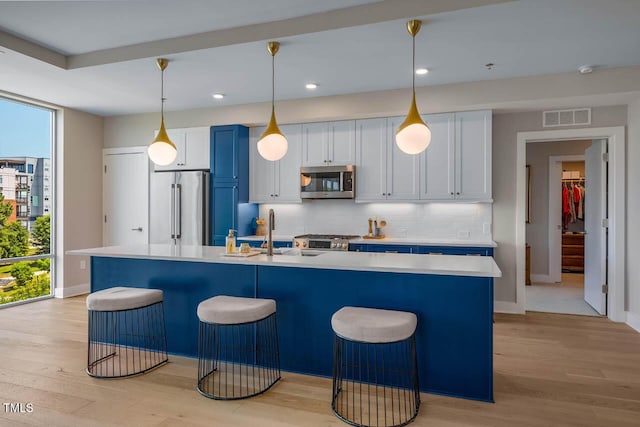214 Hunt St Unit 503, Durham, NC 27701 - kitchen with stainless steel appliances, tasteful backsplash, a breakfast bar, light wood-style floors, and light countertops