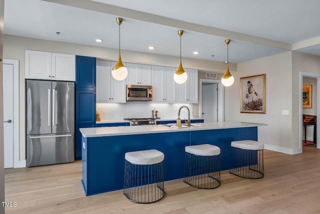 214 Hunt St Unit 503, Durham, NC 27701 - kitchen featuring appliances with stainless steel finishes, light wood-type flooring, white cabinets, backsplash, and recessed lighting