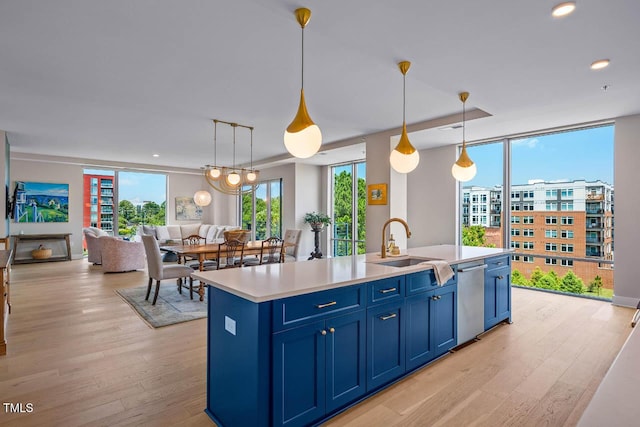 214 Hunt St Unit 503, Durham, NC 27701 - kitchen with blue cabinets, open floor plan, light wood-style floors, dishwasher, and light countertops