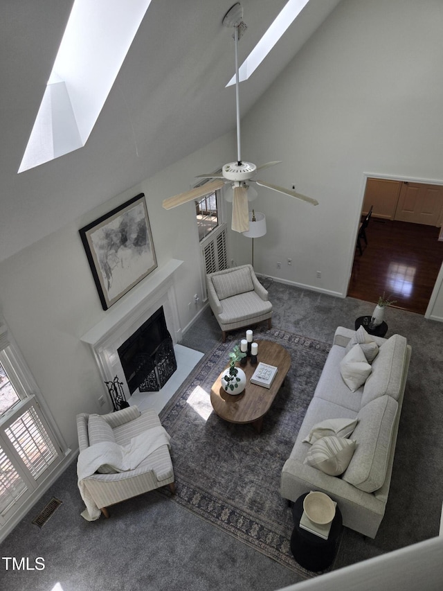 112 W Skyhawk Dr, Cary, NC 27519 - living area with a skylight, carpet, a fireplace with flush hearth, high vaulted ceiling, and ceiling fan