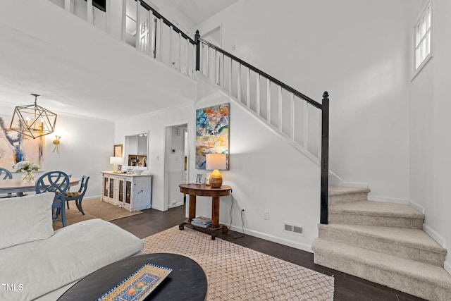 1300 Dylan Heath Ct, Raleigh, NC 27608 - living room featuring stairs, wood finished floors, a chandelier, and a towering ceiling