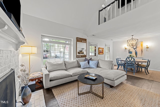 1300 Dylan Heath Ct, Raleigh, NC 27608 - living room featuring wood finished floors, a fireplace, a chandelier, and a towering ceiling