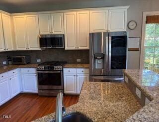 102 Shadow Ridge Pl, Chapel Hill, NC 27516 - kitchen with stainless steel appliances, dark wood-style floors, light stone counters, white cabinetry, and decorative backsplash