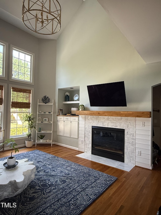 102 Shadow Ridge Pl, Chapel Hill, NC 27516 - living area with high vaulted ceiling, a fireplace with flush hearth, plenty of natural light, wood finished floors, and a chandelier