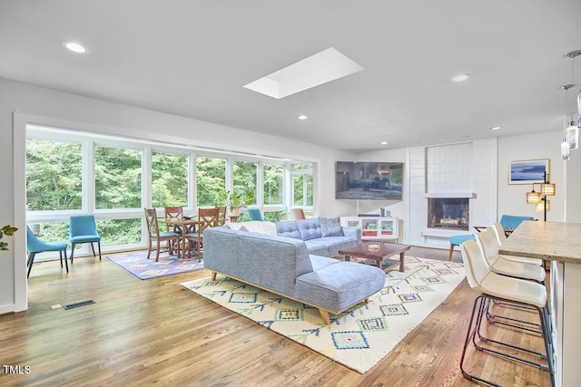 1026 Highland Woods Rd, Chapel Hill, NC 27517 - living room featuring wood finished floors, recessed lighting, a skylight, and a large fireplace