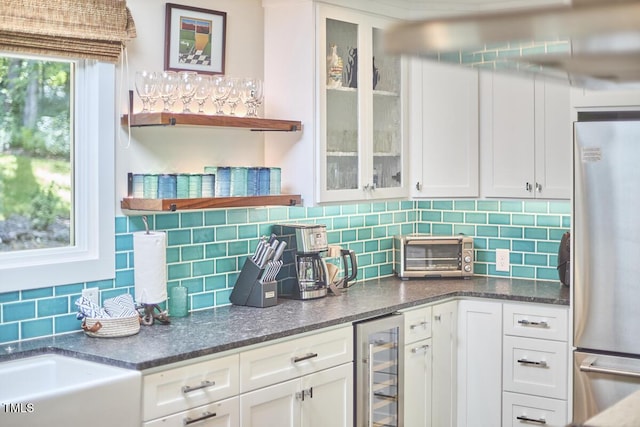 1026 Highland Woods Rd, Chapel Hill, NC 27517 - kitchen with freestanding refrigerator, beverage cooler, white cabinetry, and decorative backsplash
