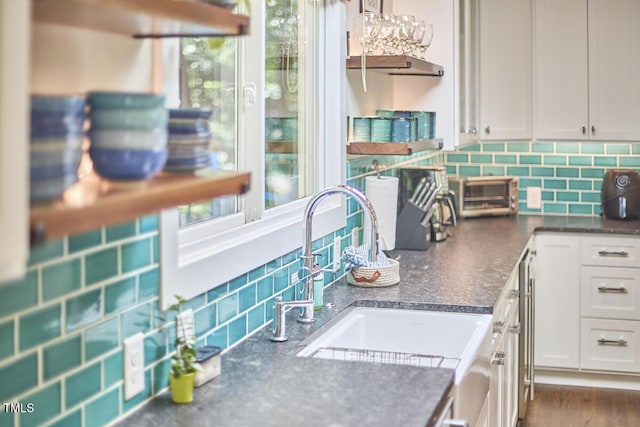 1026 Highland Woods Rd, Chapel Hill, NC 27517 - kitchen with backsplash, white cabinets, and dark countertops