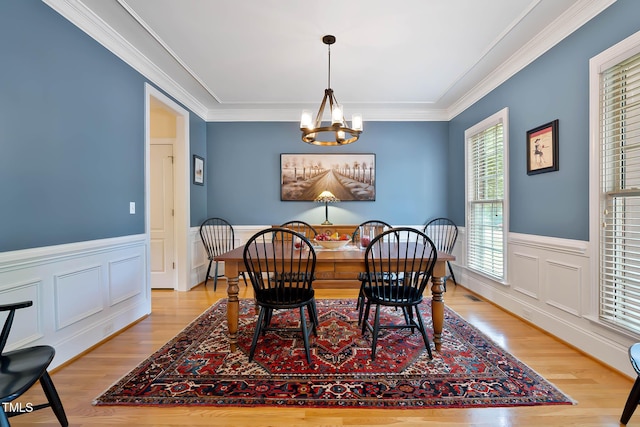 1224 Marshall Farm St, Wake Forest, NC 27587 - dining room featuring a chandelier, light wood-style floors, wainscoting, crown molding, and a decorative wall