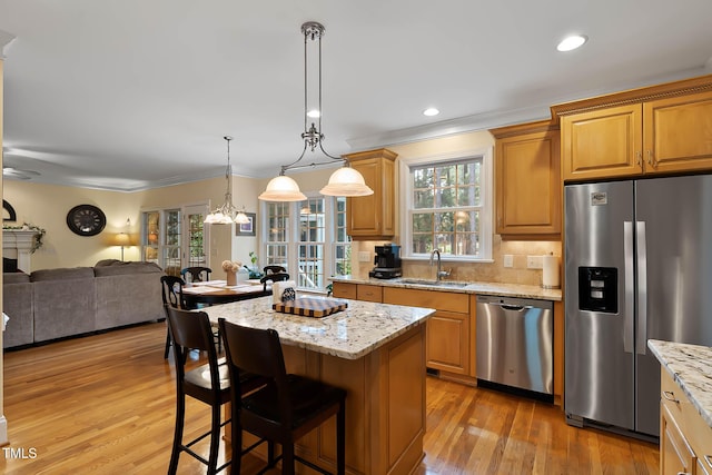 1224 Marshall Farm St, Wake Forest, NC 27587 - kitchen with appliances with stainless steel finishes, ornamental molding, open floor plan, a center island, and light wood-style flooring