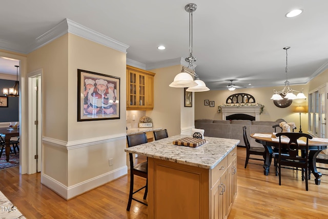 1224 Marshall Farm St, Wake Forest, NC 27587 - kitchen featuring a chandelier, a fireplace, a kitchen island, a ceiling fan, and ornamental molding