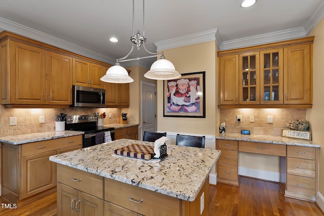 1224 Marshall Farm St, Wake Forest, NC 27587 - kitchen featuring appliances with stainless steel finishes, a kitchen island, light stone countertops, glass insert cabinets, and wood finished floors