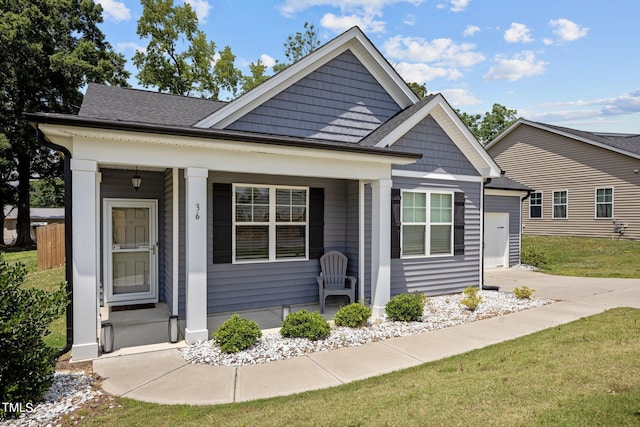 36 Mae Ct, Roxboro, NC 27573 - view of front of house featuring a porch, a front yard, roof with shingles, and driveway