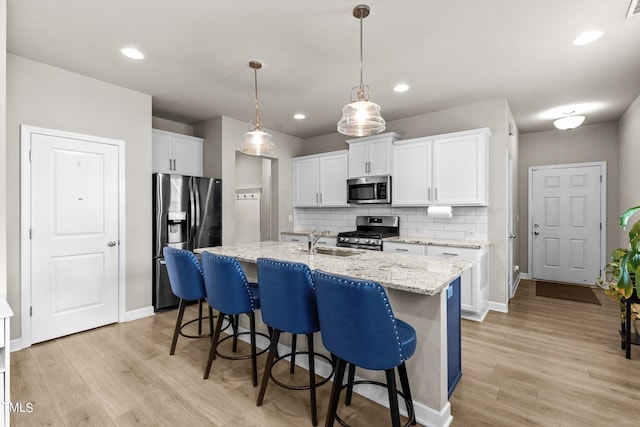36 Mae Ct, Roxboro, NC 27573 - kitchen with appliances with stainless steel finishes, tasteful backsplash, light wood-style flooring, white cabinetry, and recessed lighting