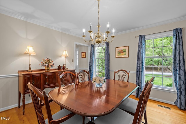 906 Grove St, Chapel Hill, NC 27517 - dining room featuring a chandelier, light wood-style flooring, plenty of natural light, and crown molding
