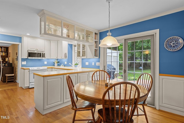 906 Grove St, Chapel Hill, NC 27517 - kitchen with stainless steel microwave, white range with electric stovetop, white cabinetry, ornamental molding, and light countertops
