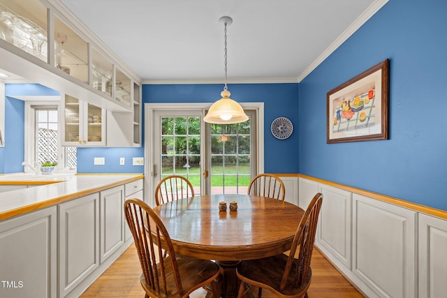 906 Grove St, Chapel Hill, NC 27517 - dining area featuring light wood finished floors, ornamental molding, and a wainscoted wall