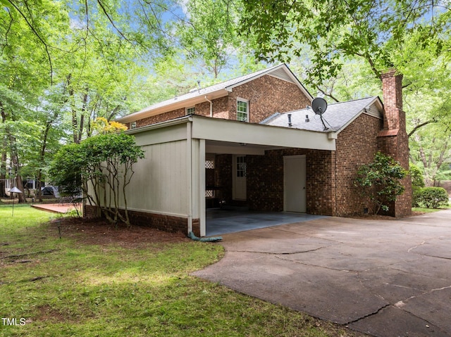 906 Grove St, Chapel Hill, NC 27517 - view of side of property featuring concrete driveway, a chimney, brick siding, and a carport