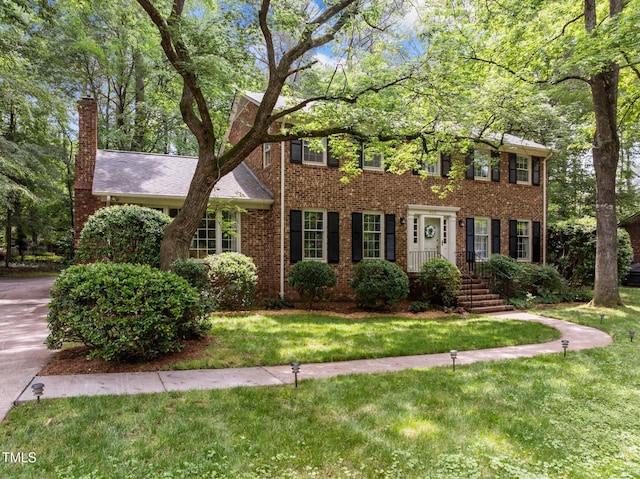 906 Grove St, Chapel Hill, NC 27517 - colonial home featuring brick siding, a front lawn, and a chimney