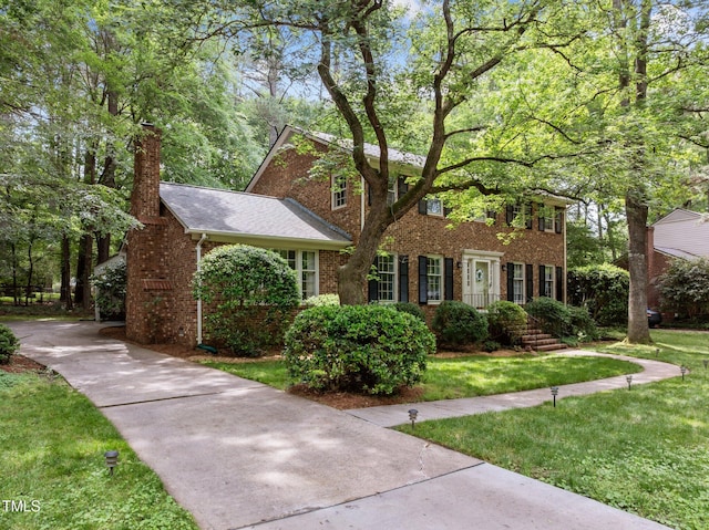 906 Grove St, Chapel Hill, NC 27517 - view of front of house with brick siding, a front yard, and a chimney