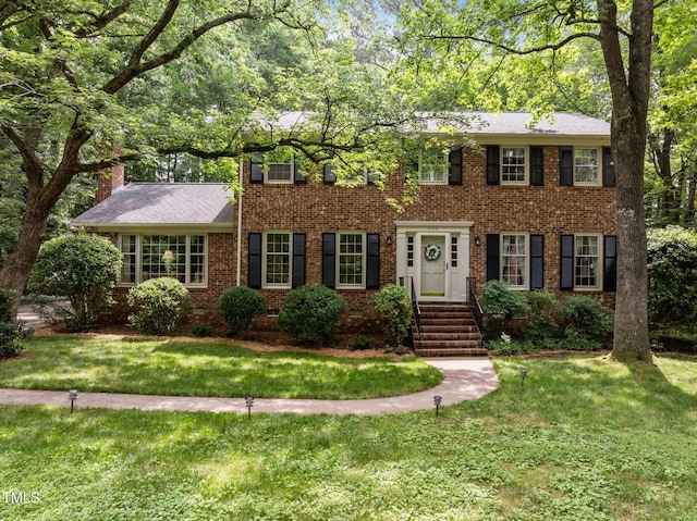 906 Grove St, Chapel Hill, NC 27517 - colonial home with brick siding, a front lawn, and a chimney