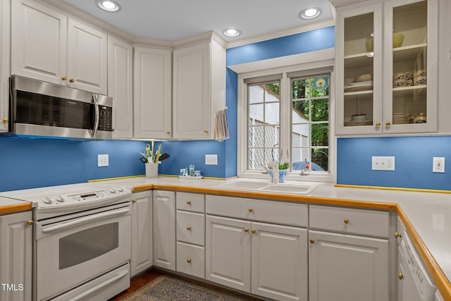 906 Grove St, Chapel Hill, NC 27517 - kitchen with white appliances, light countertops, white cabinets, glass insert cabinets, and recessed lighting