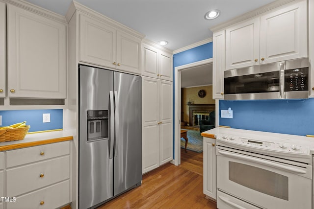 906 Grove St, Chapel Hill, NC 27517 - kitchen featuring appliances with stainless steel finishes, light countertops, light wood finished floors, white cabinets, and recessed lighting