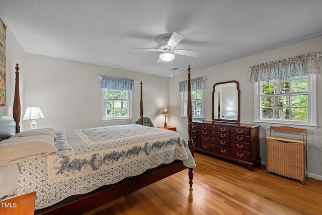 906 Grove St, Chapel Hill, NC 27517 - bedroom featuring light wood-type flooring, a textured ceiling, and ceiling fan