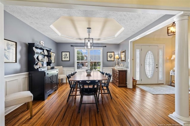 3313 Geyser Peak Rd, Fayetteville, NC 28306 - dining room with decorative columns, hardwood / wood-style flooring, a textured ceiling, a wainscoted wall, and a decorative wall