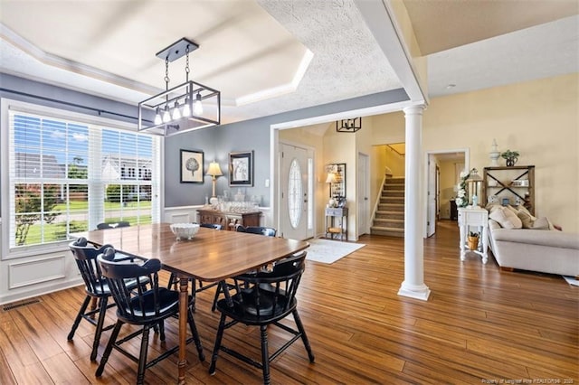 3313 Geyser Peak Rd, Fayetteville, NC 28306 - dining room featuring a raised ceiling, ornate columns, stairway, wood finished floors, and a wainscoted wall