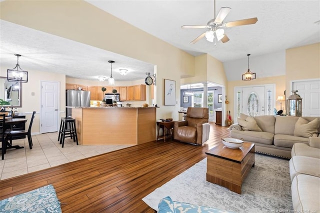 3313 Geyser Peak Rd, Fayetteville, NC 28306 - living area with light wood finished floors, lofted ceiling, a ceiling fan, a textured ceiling, and ornate columns