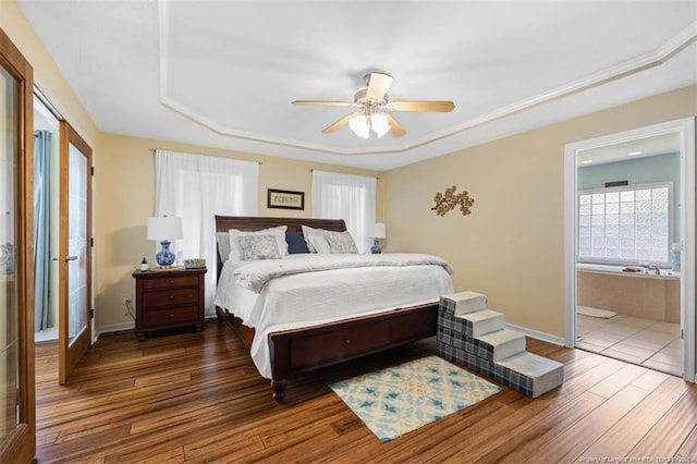 3313 Geyser Peak Rd, Fayetteville, NC 28306 - bedroom featuring a tray ceiling, wood finished floors, connected bathroom, and a ceiling fan