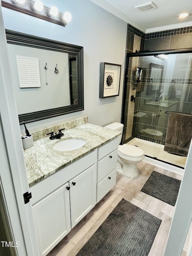 1507 Woodcroft Dr, Raleigh, NC 27609 - bathroom with vanity, a shower stall, wood finished floors, and crown molding