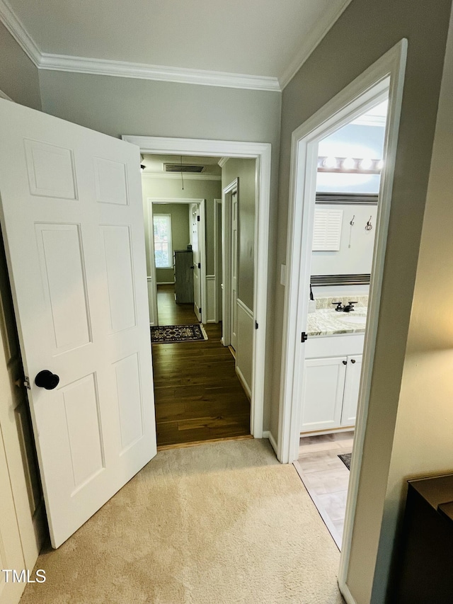 1507 Woodcroft Dr, Raleigh, NC 27609 - corridor featuring ornamental molding, attic access, light wood-type flooring, and light colored carpet