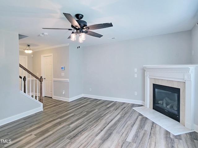 709 Pyracantha Dr, Holly Springs, NC 27540 - unfurnished living room featuring stairway, wood finished floors, a ceiling fan, a fireplace, and crown molding