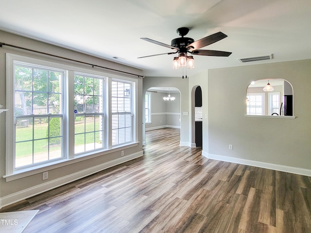 709 Pyracantha Dr, Holly Springs, NC 27540 - unfurnished room with ceiling fan, wood finished floors, arched walkways, and a chandelier