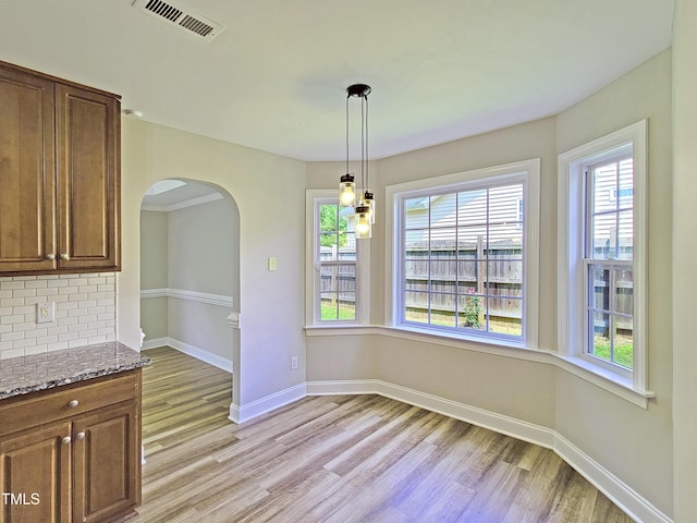 709 Pyracantha Dr, Holly Springs, NC 27540 - unfurnished dining area with arched walkways and light wood-style flooring