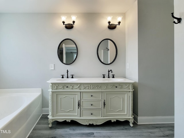 709 Pyracantha Dr, Holly Springs, NC 27540 - bathroom with wood finished floors, double vanity, and a bath