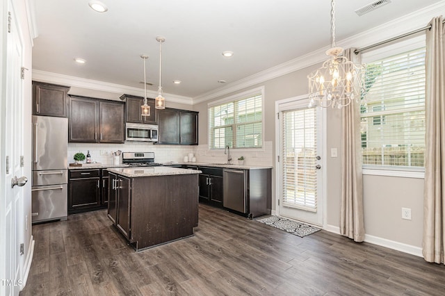 637 Stapleford Ln, Fuquay Varina, NC 27526 - kitchen with stainless steel appliances, dark brown cabinets, decorative backsplash, dark wood-style flooring, and crown molding