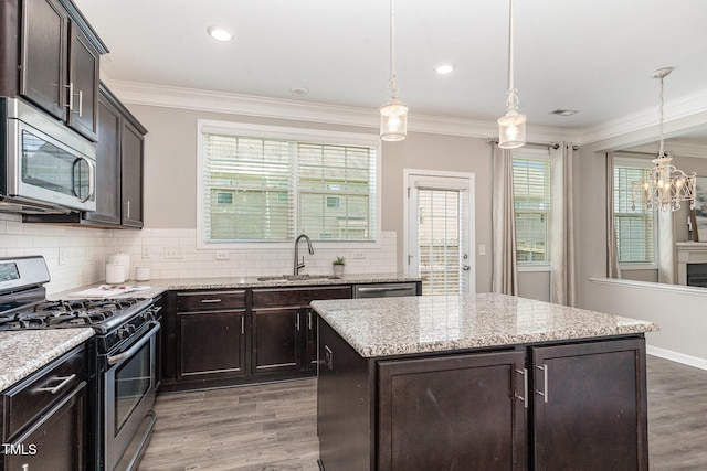637 Stapleford Ln, Fuquay Varina, NC 27526 - kitchen featuring appliances with stainless steel finishes, wood finished floors, backsplash, a chandelier, and ornamental molding
