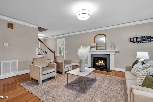 4324 Brighton Ridge Dr, Apex, NC 27539 - living area with ornamental molding, a glass covered fireplace, wood finished floors, and stairway