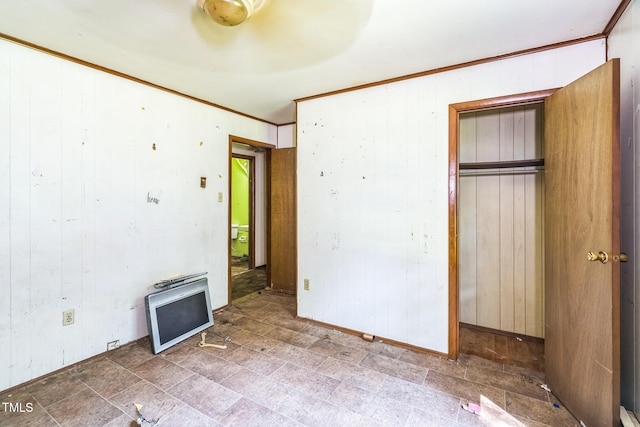 1141 Morgan Rd, Henderson, NC 27537 - unfurnished bedroom featuring ornamental molding, wooden walls, and a closet