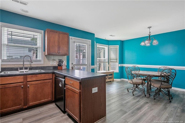 1214 Herring Gull Dr, Fayetteville, NC 28306 - kitchen with dishwasher, dark countertops, a peninsula, light wood finished floors, and a chandelier
