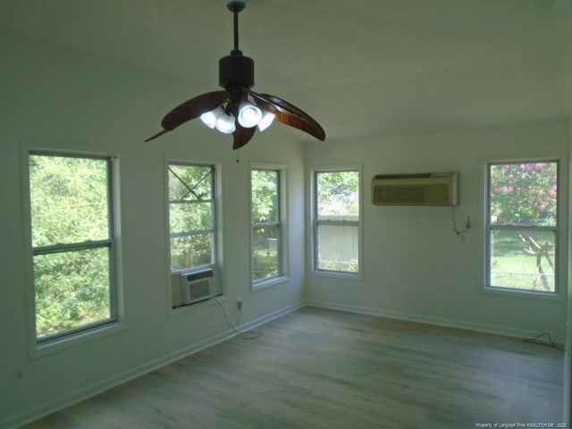 2631 Stonehaven Dr, Fayetteville, NC 28306 - empty room featuring a wall unit AC, cooling unit, wood finished floors, and ceiling fan