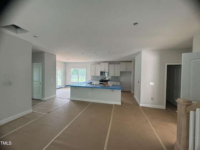 5486 Jaeger Dr Lot # 37, Graham, NC 27253 - kitchen featuring appliances with stainless steel finishes, a kitchen island with sink, and white cabinets