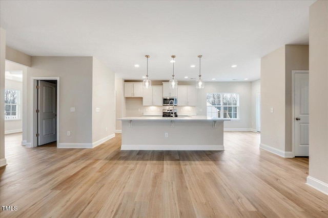 5486 Jaeger Dr Lot # 37, Graham, NC 27253 - kitchen with stainless steel microwave, white cabinetry, light countertops, recessed lighting, and light wood finished floors