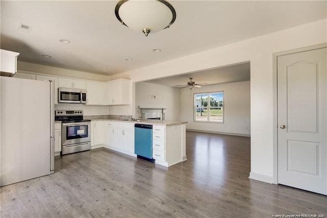 2677 NC Highway 20 W, Saint Pauls, NC 28384 - kitchen with appliances with stainless steel finishes, open floor plan, a peninsula, tasteful backsplash, and white cabinets