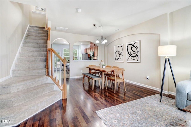 100 Stratford Lakes Dr # 322, Durham, NC 27713 - dining area with arched walkways, dark wood finished floors, stairs, and a chandelier