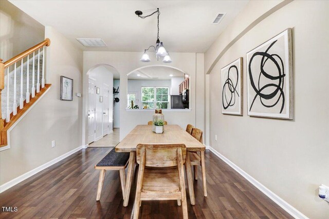 100 Stratford Lakes Dr # 322, Durham, NC 27713 - dining space with dark wood-style flooring, arched walkways, stairs, and a chandelier