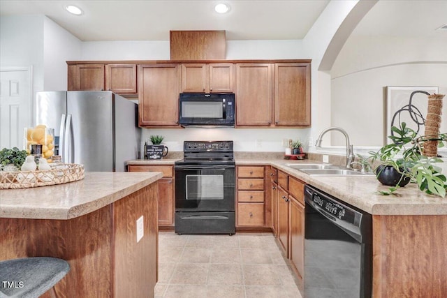 100 Stratford Lakes Dr # 322, Durham, NC 27713 - kitchen with black appliances, light countertops, a peninsula, arched walkways, and brown cabinets