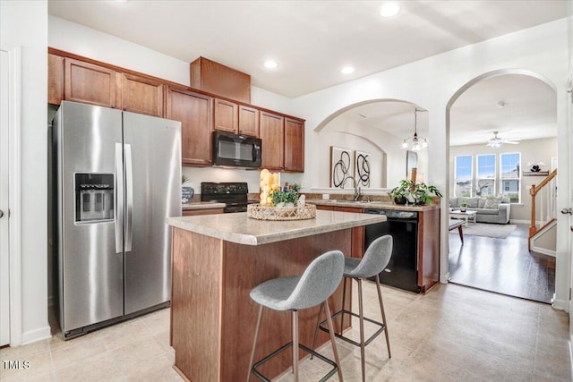 100 Stratford Lakes Dr # 322, Durham, NC 27713 - kitchen featuring black appliances, arched walkways, a kitchen island, light countertops, and recessed lighting